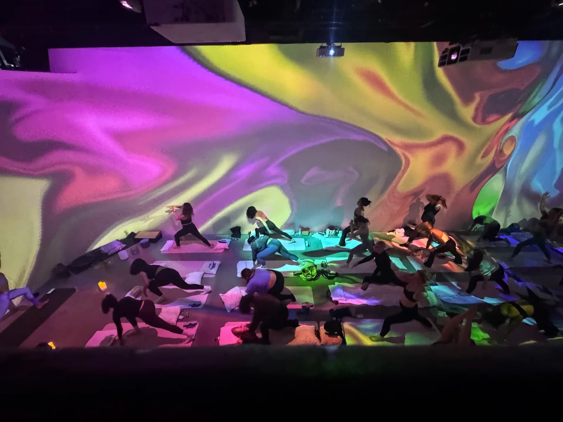 Yoga flow under purple and green marble projections