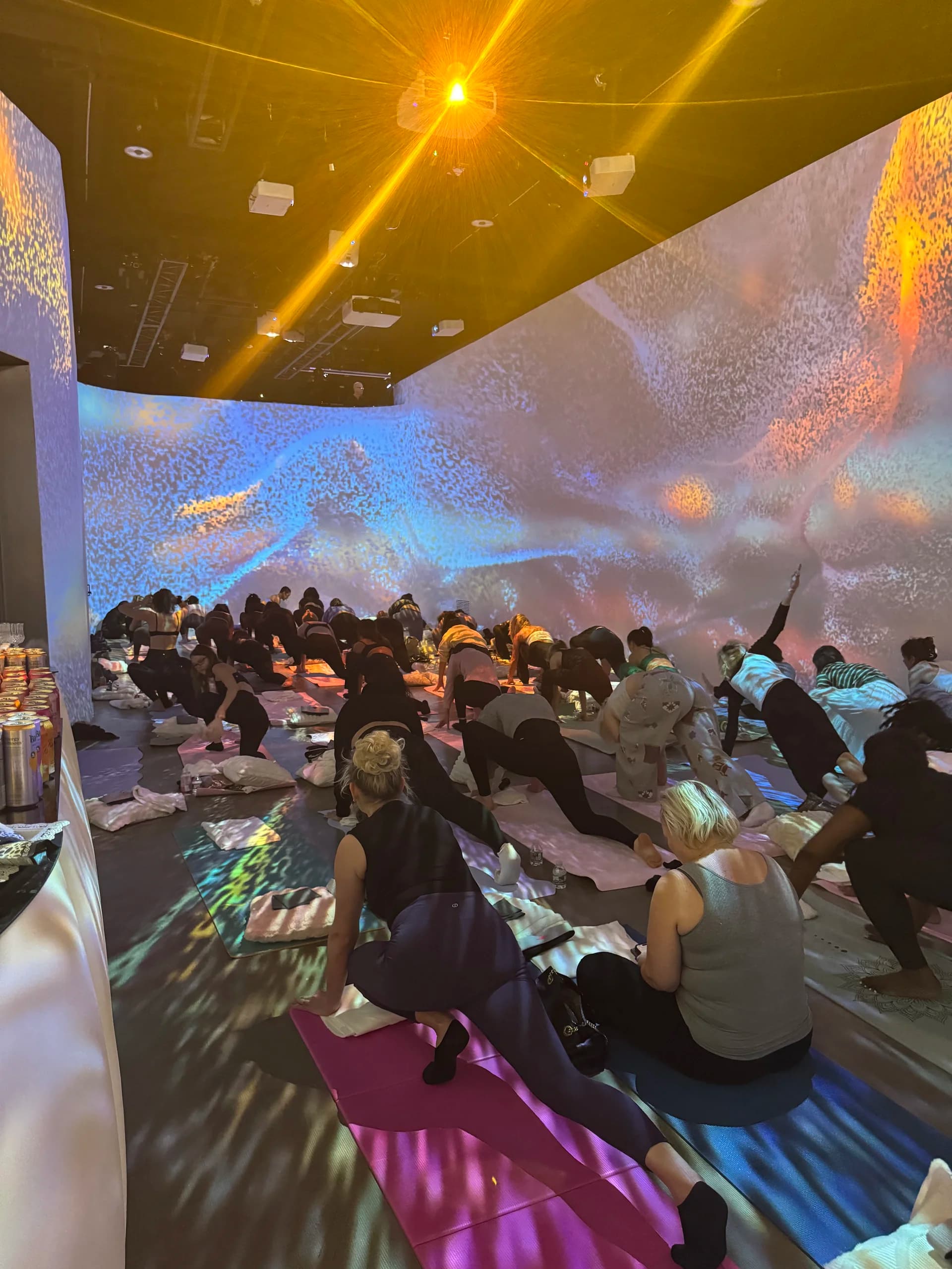 Particle burst projections in blue and pink across the room