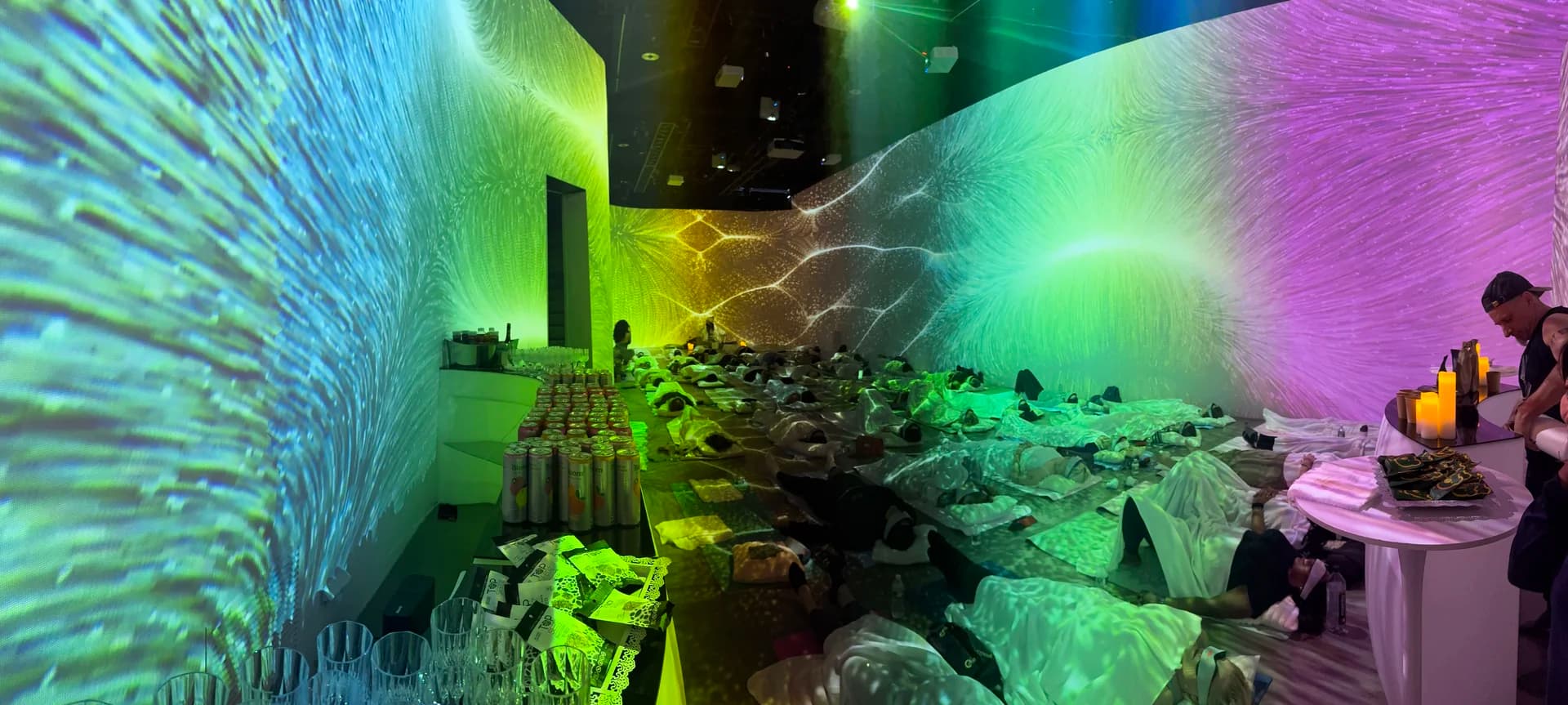 Panoramic view of green and blue fractal projections across all walls