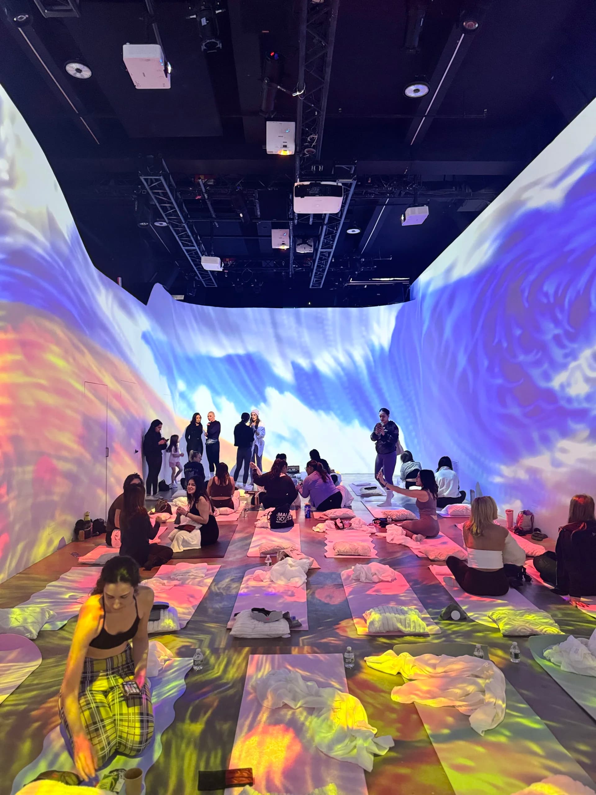 Attendees mingling under swirling ocean projections