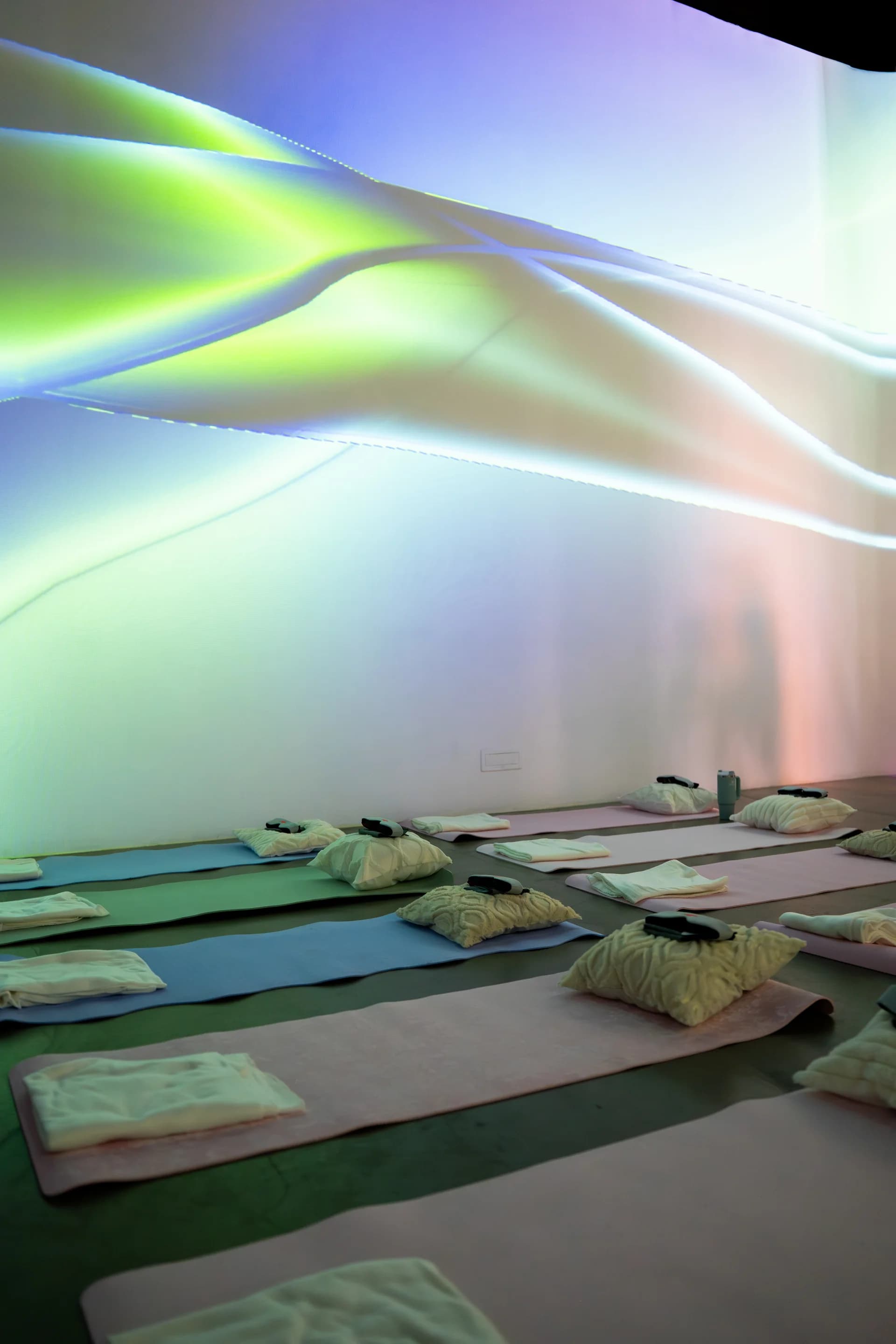 Room setup with flowing aurora generative projections on walls