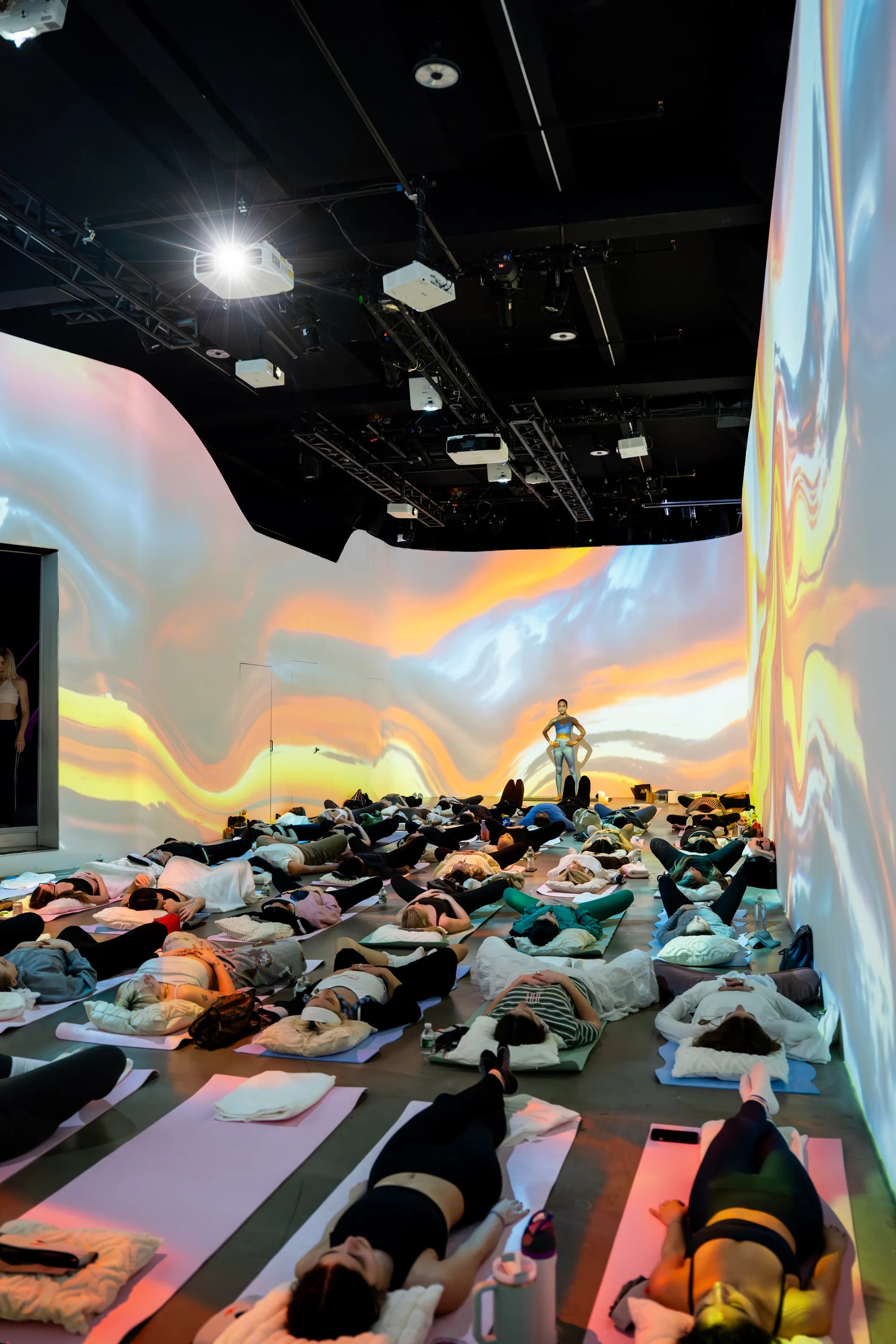 Pastel wave projections wrapping the room during savasana