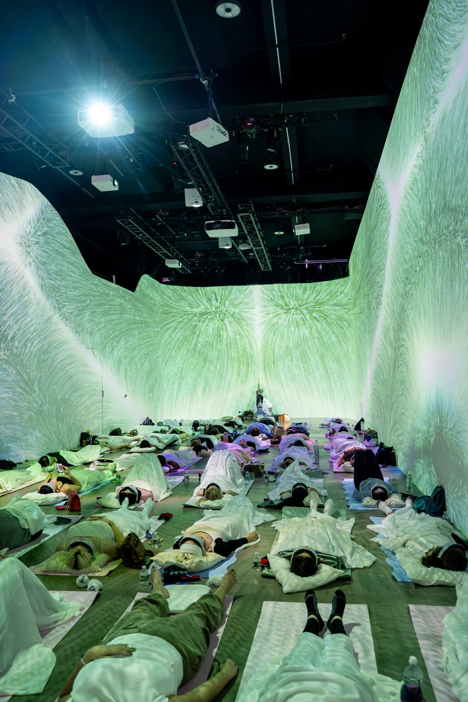 Wide view of green fractal projections wrapping the room